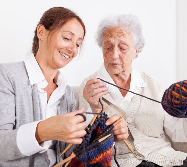 A caregiver knits with a senior client, representing companionship home care in Mount Pleasant, SC
