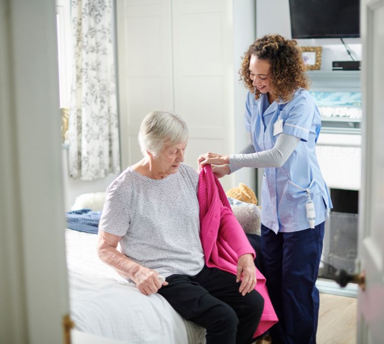 A professional caregiver helps a senior client get ready, representing personal home care in Mount Pleasant, SC.